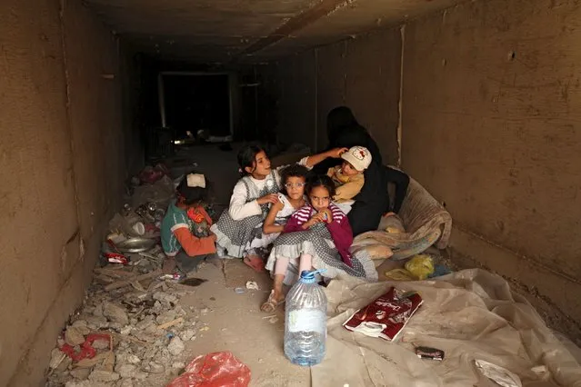 A family rest in an underground water tunnel with other displaced Yemeni families (not pictured), after they were forced to flee their home due to ongoing air-strikes carried out by the Saudi-led coalition in Sanaa May 2, 2015. (Photo by Mohamed al-Sayaghi/Reuters)