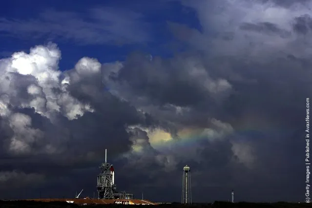 A rainbow arcs past the space shuttle Discovery as it sits on launch pad 39A at the Kennedy Space Center in Cape Canaveral