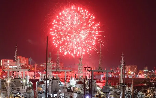 Fireworks go off over the city during New Year celebrations in Vladivostok, Russia on December 31, 2021. (Photo by Yuri Smityuk/TASS)