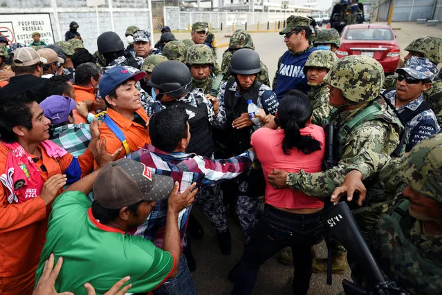 Relatives of injured or missing workers scuffle with Mexican marines blocking the access to Mexican national oil company Pemex's Pajaritos petrochemical complex in Coatzacoalcos, Veracruz state, Mexico, April 21, 2016. (Photo by Angel Hernandez/Reuters)