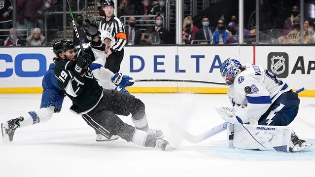 Los Angeles Kings left wing Alex Iafallo, left, slides into Tampa Bay Lightning goaltender Andrei Vasilevskiy, right, as he tries to score while right wing Mathieu Joseph defends during the second period of an NHL hockey game Tuesday, January 18, 2022, in Los Angeles. (Photo by Mark J. Terrill/AP Photo)