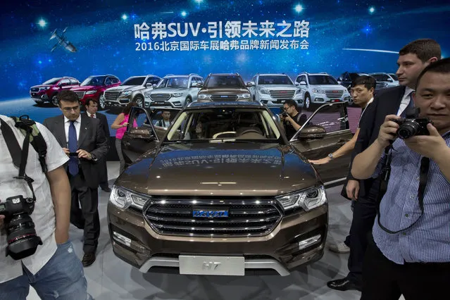 Visitors to the Auto China 2016 examine the latest SUV from Chinese automaker Haval in Beijing, China, Monday, April 25, 2016. (Photo by Ng Han Guan/AP Photo)