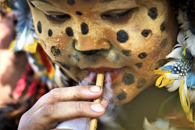 An Indigenous woman smokes during a protest demanding a better health care system be made available in her region, including the hiring of more doctors and nurses as well as the building of more clinics, outside the Ministry of Health in Brasilia, Brazil, Wednesday, February 8, 2023. (Photo by Gustavo Moreno/AP Photo)