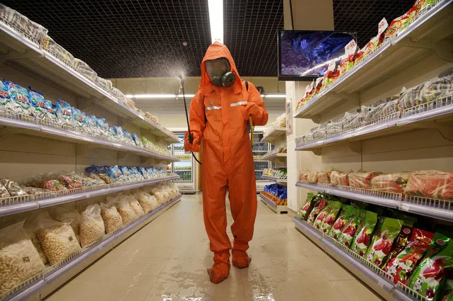 A health official sprays disinfectant as part of preventative measures against Covid-19, in the Daesong Department Store in Pyongyang on September 27, 2021. (Photo by Kim Won Jin/AFP Photo)