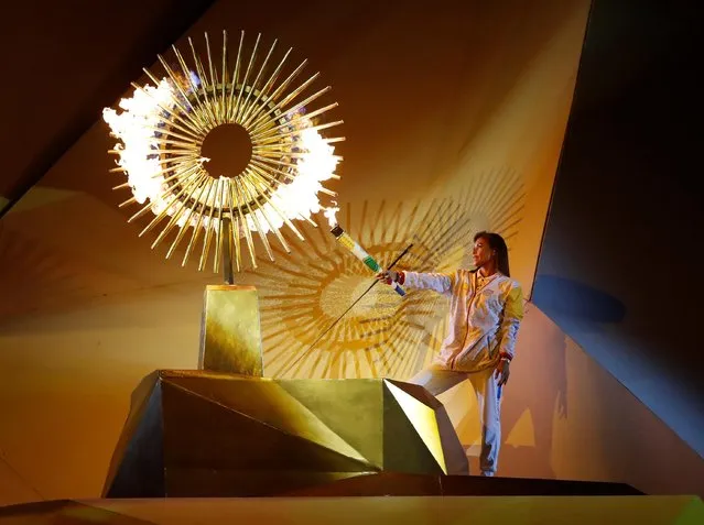 Olympic silver medalist Cecilia Tait, of Peru, lights the Pan American flame during the Opening Ceremony at the National stadium in Lima, Peru, Friday, July 26, 2019. (Photo by Henry Romero/Reuters)