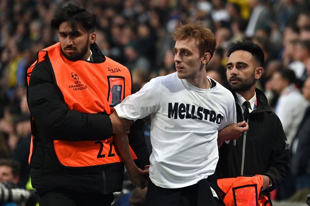 A pitch invader is chased by security officers during the UEFA Champions League final football match between Borussia Dortmund and Real Madrid, at Wembley stadium, in London, on June 1, 2024. (Photo by Glyn Kirk/AFP Photo)
