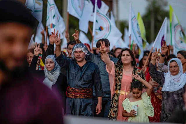 Syrian Kurdish demonstrators flash the V for victory sign as they march in the northeastern city of Qamishli on August 27, 2019 during a protest against Turkish threats to invade the Kurdish region. The Kurdish authorities in northeast Syria said Tuesday their forces had started to withdraw from outposts along the Turkish border after a US-Turkish deal for a buffer zone there. (Photo by Delil Souleiman/AFP Photo)