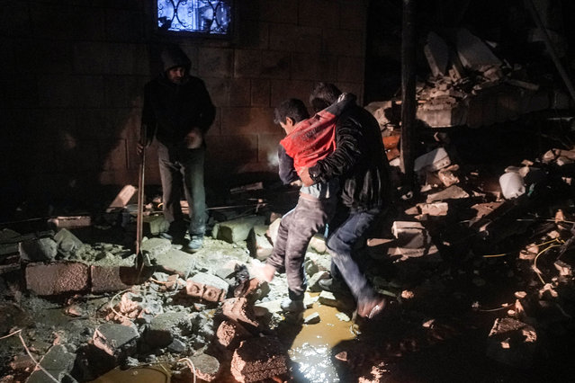 A man carries away an injured child following an earthquake in the town of Jandaris, in the countryside of Syria's northwestern city of Afrin in the rebel-held part of Aleppo province, early on February 6, 2023. At least 42 have been reportedly killed in north Syria after a 7.8-magnitude earthquake that originated in Turkey and was felt across neighbouring countries. (Photo by Rami al Sayed/AFP Photo)