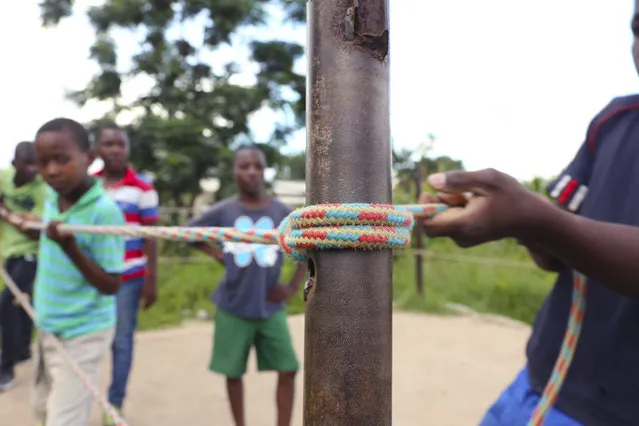 In this Saturday, February 12, 2017 photo, children prepare a boxing ring in Chitungwiza, ZImbabwe. (Photo by Tsvangirayi Mukwazhi/AP Photo)