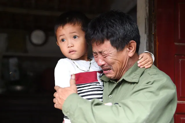 Le Minh Tuan, father of 30-year old Le Van Ha, who is feared to be among the 39 people found dead in a truck in Britain, cries while holding Ha's son outside their house in Vietnam's Nghe An province on October 27, 2019. (Photo by Nhac Nguyen/AFP Photo)