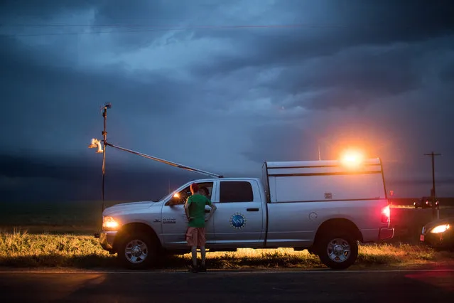 Hunter Anderson, intern with the Center For Severe Weather Research, consults with Rachel Humphrey, support scientist and driver of a tornado scout vehicle, as they observe a supercell thunderstorm as it bears down on the area, May 9, 2017 in Lamb County, Texas. (Photo by Drew Angerer/Getty Images)