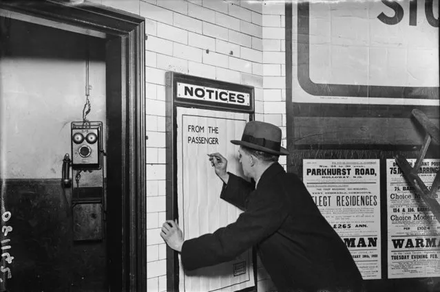 A man writing on a complaints poster on the London Underground, 1922. (Photo by Topical Press Agency/Getty Images)