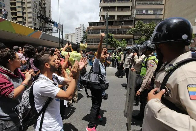 People confront police during a protest demanding food, a few blocks from Miraflores presidential palace in Caracas, Venezuela, Thursday, June 2, 2016. (Photo by Fernando Llano/AP Photo)