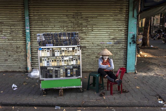 A vendor selling used remote controls for various home appliances takes a nap in Nhat Tao market, the largest informal recycling market in Ho Chi Minh City, Vietnam, Sunday, January 28, 2024. (Photo by Jae C. Hong/AP Photo)