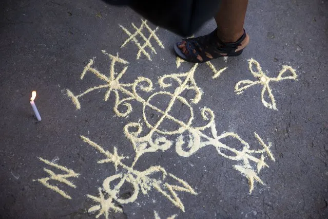 Vodou iconography is seen on the floor during the funeral of Euvonie Georges Auguste, a prominent Vodou priestess and secretary general of Haiti's National Conference of Voodooists, in Port-au-Prince, Saturday, April 9, 2022. Euvonie Georges Auguste was outspoken on political issues, taking part in meetings held by the Organization of American States and participating in the successful campaign to make Vodou an official religion in Haiti in the early 2000s. (Photo by Joseph Odelyn/AP Photo)