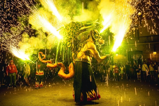 “Atzeries”, a fire beast sets off his fire crackers during a “Correfocs” in Barcelona's Gracia neighborhood, Spain on May 27, 2023. (Photo by Matthias Oesterle/Alamy Live News)