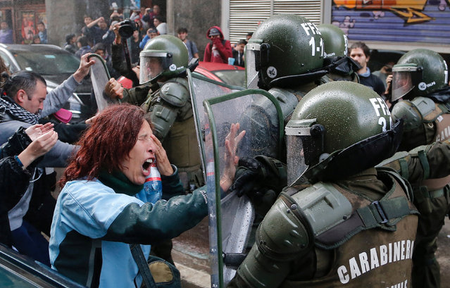 A demonstrator clashes with riot police during a protest against government education reforms  in Valparaiso city, Chile, June 9, 2016. (Photo by Rodrigo Garrido/Reuters)