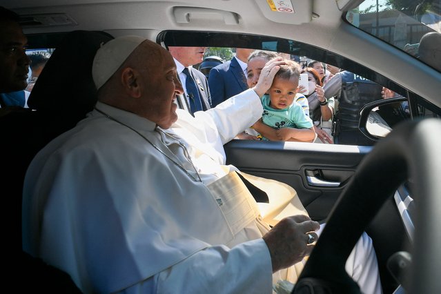 In this handout picture released by the Vatican Press Office on September 5, 2024 Pope Francis blesses a child as he arrives for a meeting with beneficiaries from charitable organizations, during his apostolic visit to Asia, at Indonesian Bishops' Conference headquarters in Jakarta. Pope Francis's gruelling tour of the Asia-Pacific got into full swing on September 4, with the 87-year-old appearing in good health and strong spirits as he met Indonesia's president. (Photo by Handout/Vatican Media via AFP Photo)