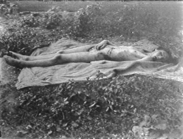The naked corpse of Helga Goebbels (1932 - 1945), oldest child of German Nazi Propaganda Minister Joseph Goebbels, lies on a blanket in a field after Russian troops moved her and her siblings' bodies from the beds in the bunker where their parents poisoned them, Berlin, May 1945. The Russians buried the bodies but disinterred them 15 years later, burned them, and scattered the ashes in a river. (Photo by Express Newspapers/Getty Images)