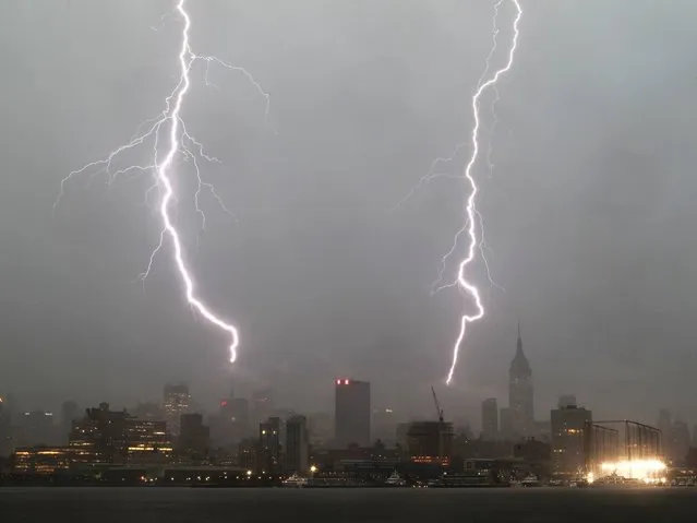 Two bolts of lightning hit midtown Manhattan during a storm in New York on July 2, 2014. (Photo by Gary Hershorn/Corbis Images)