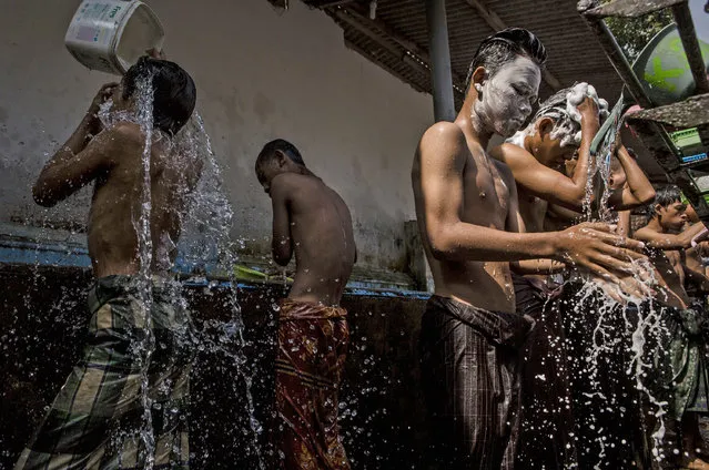 Students take a shower at the islamic boarding school Lirboyo during the holy month of Ramadan on June 10, 2016 in Kediri, East Java, Indonesia. The Islamic boarding school, Lirboyo, was founded by KH Abdul Karim in 1910, and known to be one of the largest traditional “Pesantren” in Indonesia, with around 17,000 students in Kediri, East Java. Students at the Pesantren, also known as “Santri”, are separated from their families and spend their days studying Islamic scriptures, reading the Quran and learning Arabic in addition to other activities which begins with the morning prayer at 4am till midnight. (Photo by Ulet Ifansasti/Getty Images)
