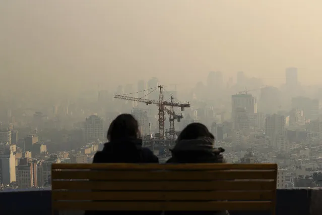 People look at the skyline through polluted air, in the Velenjak mountainous area of Tehran, Iran Monday, December 23, 2019. Dangerously poor air quality forced Iran’s government on Monday to keep all schools closed in the capital, Tehran, and other cities. Schools were closed since Saturday, and will remain closed until Wednesday, the end of the week in Iran, according to the official IRNA news agency. Tehran’s air is among the most polluted in the world. (Photo by Ebrahim Noroozi/AP Photo)