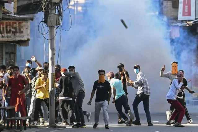 Protestors take part in a demonstration amid tear gas smoke fired by Indian security forces to disperse them in Srinagar on May 25, 2022, over the sentencing hearing of pro-independence party Jammu Kashmir Liberation Front chairman Yasin Malik. (Photo by Tauseef Mustafa/AFP Photo)