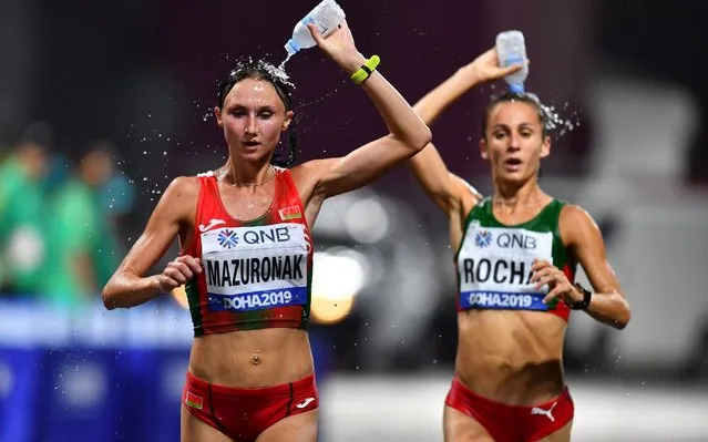 Belarus' Volha Mazuronak and Portugal's Salome Rocha try to keep cool during the Women's Marathon at the World Athletics Championships in Doha, Qatar on September 28, 2019. In an attempt to beat the heat, the event started at midnight, but still 28 of the 68 athletes did not finish. (Photo by Dylan Martinez/Reuters)