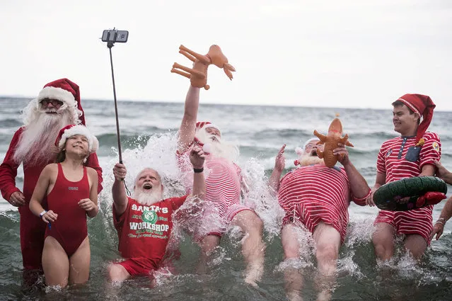 People dressed as Santa Claus bathe in the sea as they take part in the World Santa Claus Congress, an annual event held every summer at the amusement park Dyrehavsbakken, in Copenhagen, Denmark on July 26, 2017. (Photo by Sarah Christine Noergaard/Reuters/Scanpix Denmark)