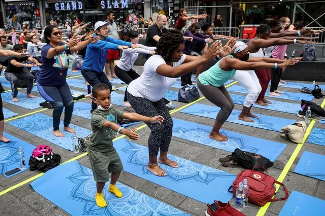 People participate in the “Solstice in Times Square: Mind Over Madness Yoga” to celebrate the summer solstice in New York City, U.S., June 21, 2022. (Photo by Brendan McDermid/Reuters)