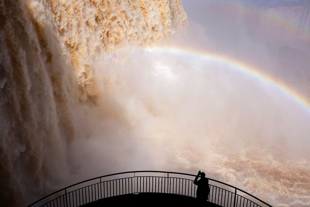 A tourist takes a picture at Iguazu Falls, which are currently at full water capacity due to the rains in southern Brazil, at Iguazu Falls, Brazil on May 7 2024. (Photo by Kiko Sierich/Reuters)