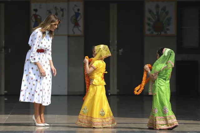 U.S. first lady Melania Trump waits to be garlanded by two children at Sarvodaya Co-Educational Senior Secondary School in New Delhi, India, Tuesday, February 25, 2020. (Photo by Altaf Qadri/AP Photo)