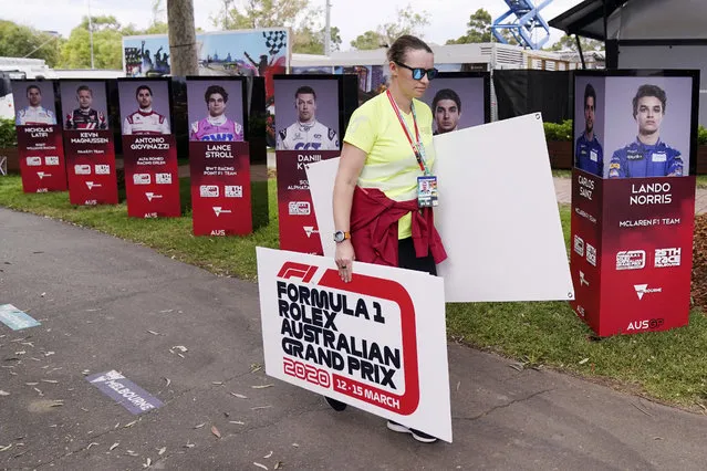A woman takes away signs after the cancellation of the Australian Formula One Grand Prix in Melbourne, Friday, March 13, 2020. The first F1 Grand Prix of the season was canceled two hours before the first official practice was set to start Friday after organizers relented to pressure to call it off amid the spreading coronavirus. (Photo by Michael Dodge/AAP Image via AP Photo)
