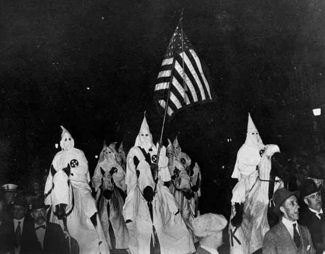 In this September 21, 1923 file photo, members of the Ku Klux Klan ride horses during a parade through the streets of Tulsa, Okla. Former Sheriff Bill McCullough, who tried to stop the parade, is at foreground left. (Photo by AP Photo)