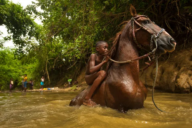 This image of a young bareback rider was taken in the village of Palenque de San Basilio, in Colombia’s Bolívar department. Founded by freed slaves in the 17th century, it became the first free town in the Americas, following a decree by the Spanish crown. Most of today’s inhabitants are direct descendants of those slaves and have preserved many of their customs, including their own language, Palenquero. (Photo by Sebastián Suki Beláustegui/The Guardian)