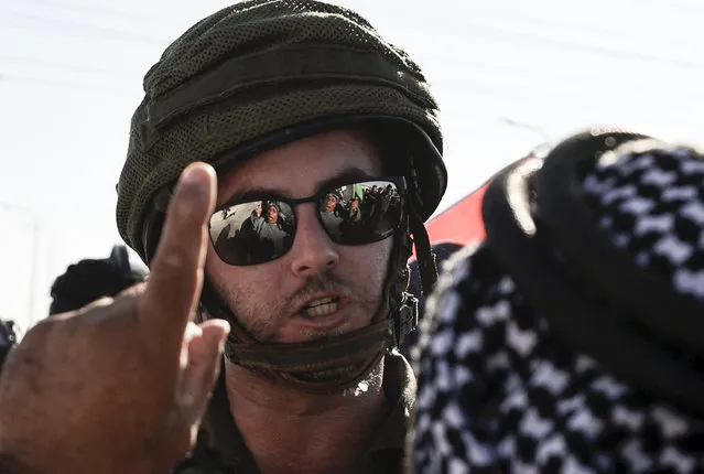 A Palestinian man argues with a member of the Israeli security forces, during a demonstration by Palestinians and Israeli peace activists against settlement expansion, in the occupied West Bank town of Salfit, on July 27, 2022. (Photo by Jaafar Ashtiyeh/AFP Photo)