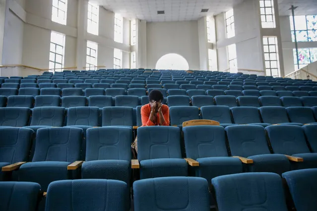 A woman attends a Sunday mass service at the Nairobi Baptist Church, which was streamed live on the internet with almost no attendees in order to limit the spread of the new coronavirus, in the capital Nairobi, Kenya Sunday, March 22, 2020. In Kenya, the Ministry of Health has banned all public gatherings and meetings in order to limit the spread of the new coronavirus that causes COVID-19 but has permitted normal church services to continue so long as they provide hand sanitizing or washing facilities to attendees. (Photo by Brian Inganga/AP Photo)