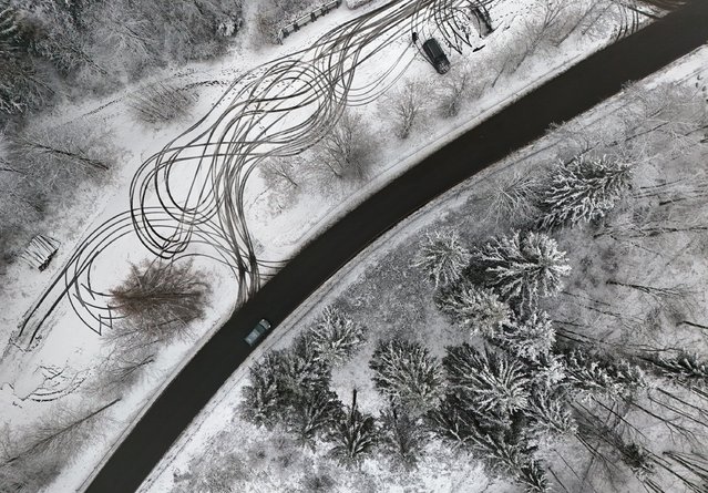 An aerial view shows a parking site and trees covered in snow near Winterberg, western Germany on November 20, 2024. (Photo by Ina Fassbender/AFP Photo)