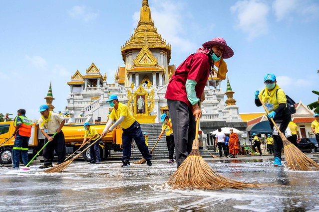 Volunteers use disinfectant to clean Wat Traimit temple in Bangkok on March 18, 2020, amid concerns over the COVID-19 coronavirus outbreak across the world. Wat Traimit is the home of 5.5 tonnes (11,000 lbs.) of pure gold Buddha statues and attracts thousands of tourists each day. (Photo by Mladen Antonov/AFP Photo)