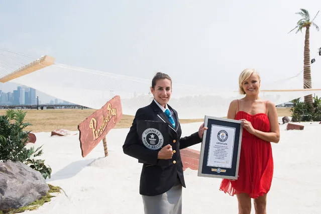 Hollywood actress Malin Akerman, right, helps King Digital Entertainment set the Guinness World Record for the World's Largest Hammock to celebrate the launch of its new game Paradise Bay on Wednesday, September 2, 2015, in Jersey City, N.J. (Photo by Charles Sykes/Invision for King World Entertainment/AP Images)