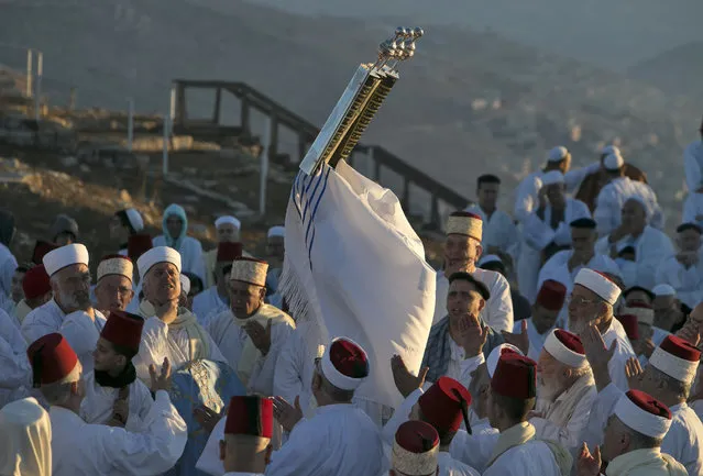 Samaritans pray on top of Mount Gerizim, near the northern West Bank city of Nablus, during celebrations for the holiday of Sukkot (the Tabernacles Feast), which marks the exodus of the ancient Hebrew people from Egypt, on October 4, 2017. Samaritans are a community of a few hundred people living in Israel and in the Nablus area, who trace their lineage to the ancient Israelites Moses led out of Egypt. (Photo by Jaafar Ashtiyeh/AFP Photo)