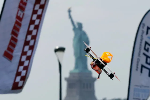 A pilot flies a small racing drone through an obstacle course on Governors Island, a former military installation in New York Harbor, Friday, August 5, 2016. Drone pilots are gathering in New York City to compete in the National Drone Racing Championship. (Photo by Richard Drew/AP Photo)