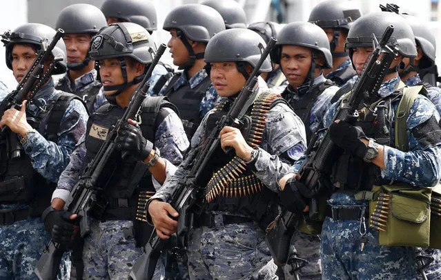 An armed unit of the Philippine Coast Guard, who have been deployed in Marawi in southern Philippines to augment government troops in its fight against Muslim militants, stand at attention as they are welcomed upon docking at Manila's South Harbor Friday, November 3, 2017 in Manila, Philippines. Government forces began pulling out of the besieged city of Marawi following its liberation from the militants who laid siege to the city for five months. (Photo by Bullit Marquez/AP Photo)