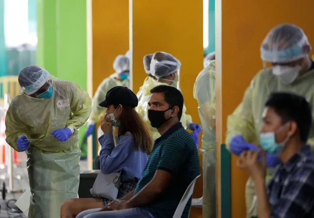 Essential workers have their noses swabbed before returning to the workforce at a regional screening center amid the coronavirus disease (COVID-19) outbreak in Singapore on June 9, 2020. (Photo by Edgar Su/Reuters)