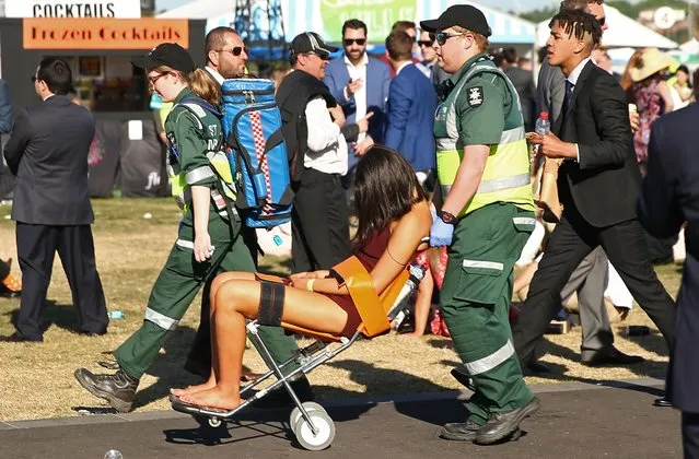 A racegoer is assisted by ambulance workers following 2017 Stakes Day at Flemington Racecourse on November 11, 2017 in Melbourne, Australia. (Photo by Getty Images/Stringer)