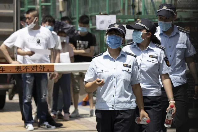 Workers leave from a coronavirus testing center set up outside a sports facility in Beijing, Tuesday, June 16, 2020. China reported several dozen more coronavirus infections Tuesday as it increased testing and lockdown measures in parts of the capital to control what appeared to be its largest outbreak in more than two months. (Photo by Ng Han Guan/AP Photo)