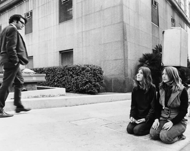 Two members of the Charles Manson “family” known as Kitty Lutesinger, left, and Kathy Gillies, kneel on the sidewalk outside the Los Angeles Hall of Justice, December 30, 1970, while the trial of Charles Manson and three women co-defendants on murder charges goes on inside. Members of the Manson cult have maintained almost a continuous vigil for weeks, saying they'll wait “until Charlie is freed”. (Photo by David F. Smith/AP Photo)