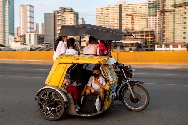 Students ride a motorcycle in Manila, Philippines on October 24, 2022. (Photo by Lisa Marie David/Reuters)