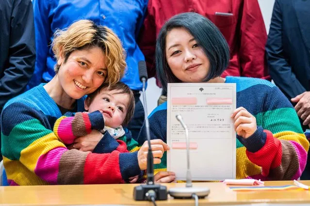 Mamiko Moda (L) and her partner Satoko Nagamura with their son holds a same-sеx partnership certificate as they pose for a photograph after a press conference at the Tokyo Metropolitan Government building in Tokyo on November 1, 2022. Tokyo began issuing partnership certificates to same-sеx couples who live and work in the capital on November 1, a long-awaited move in a country without marriage equality. (Photo by Yuichi Yamazaki/AFP Photo)