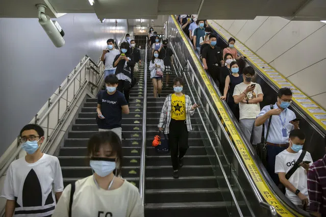 Commuters wearing face masks to protect against the spread of the new coronavirus walk through a subway station in Beijing, Thursday, July 9, 2020. (Photo by Mark Schiefelbein/AP Photo)
